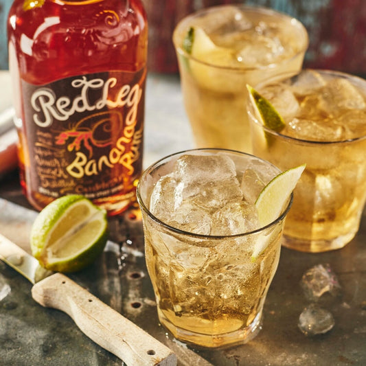 RedLeg Banana Rum with 3 short glasses, filled with ice and limes