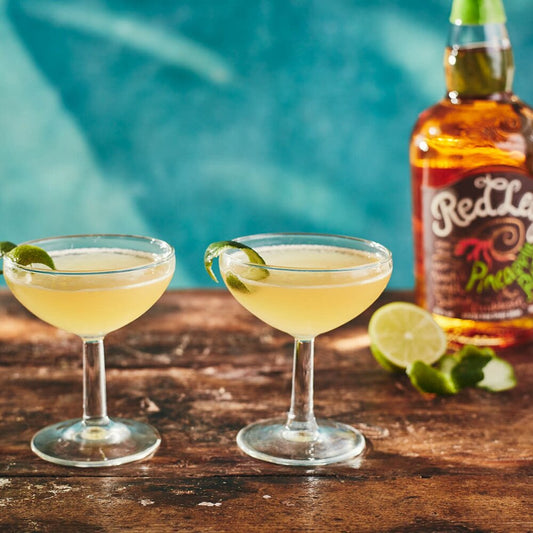 Pineapple Daiquiri in a martini glass garnished with lime on a wooden surface